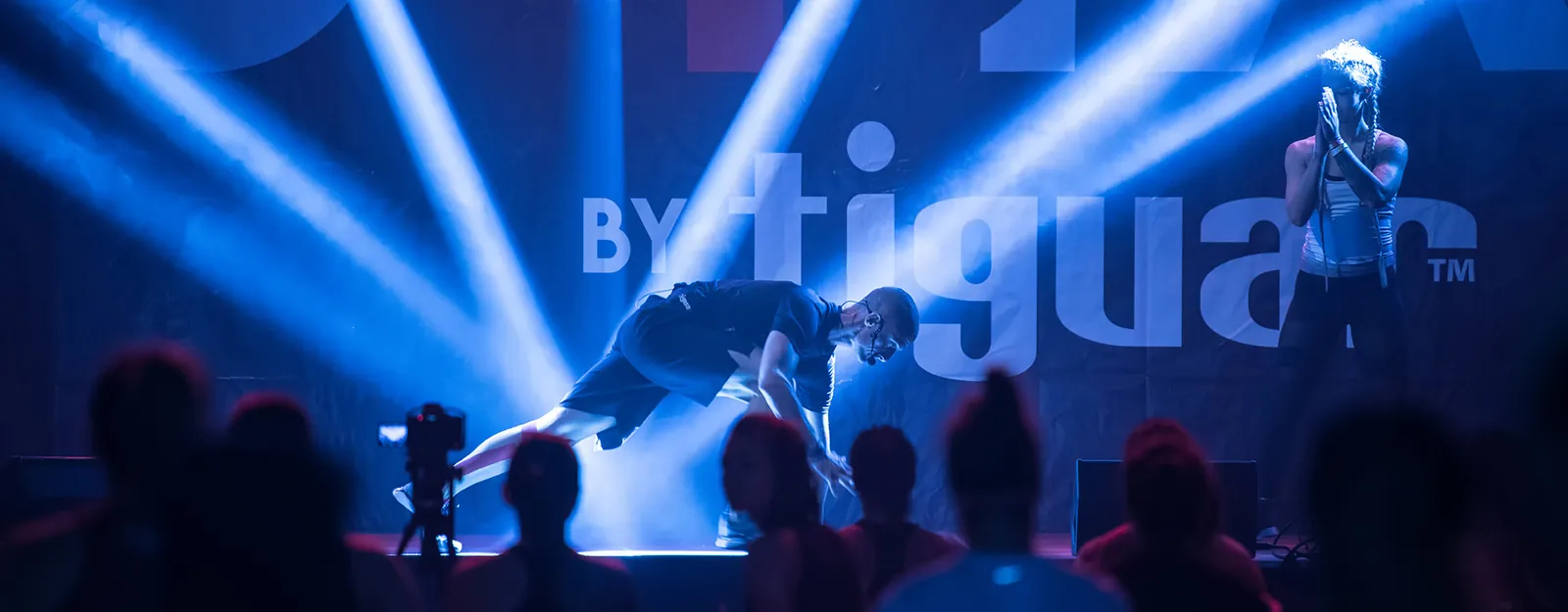 Instructor mid-demonstration on the EU4YA main stage under blue beams